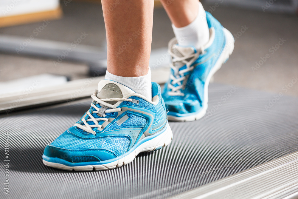 Woman running on treadmill in gym.