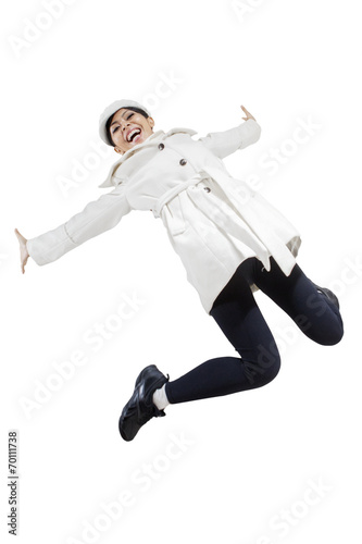 Woman in winter jacket jumping in studio