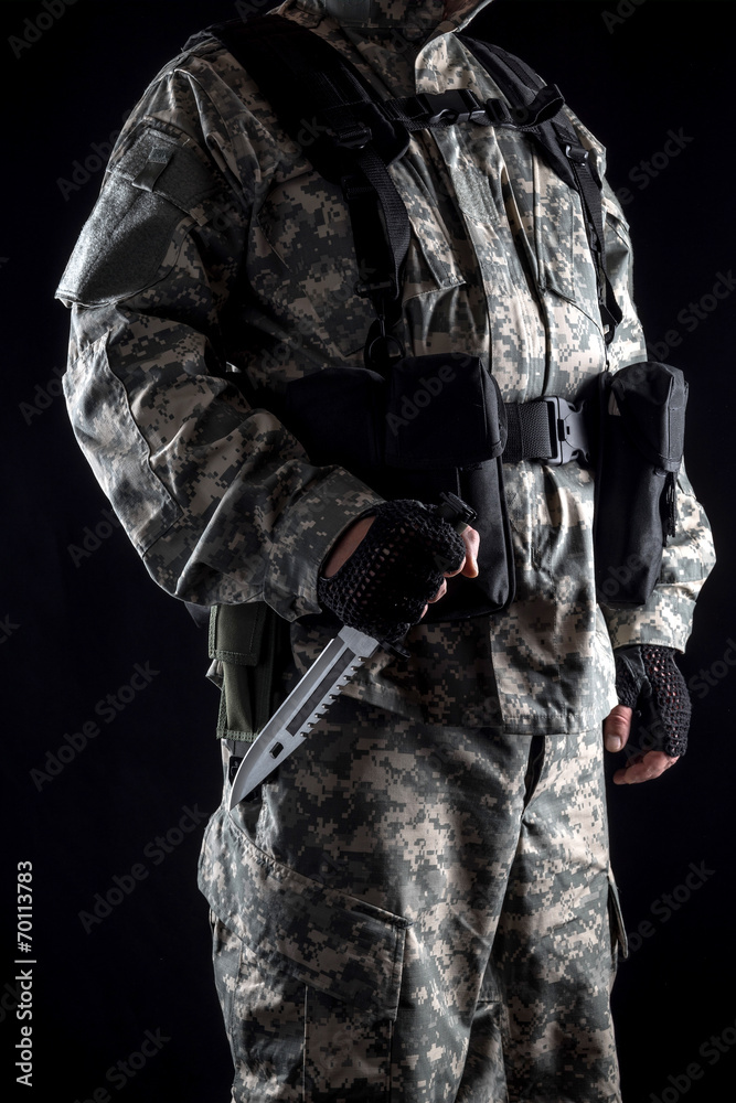 Military man with a knife in a hand on the black background Military man with a knife in a hand on the black background