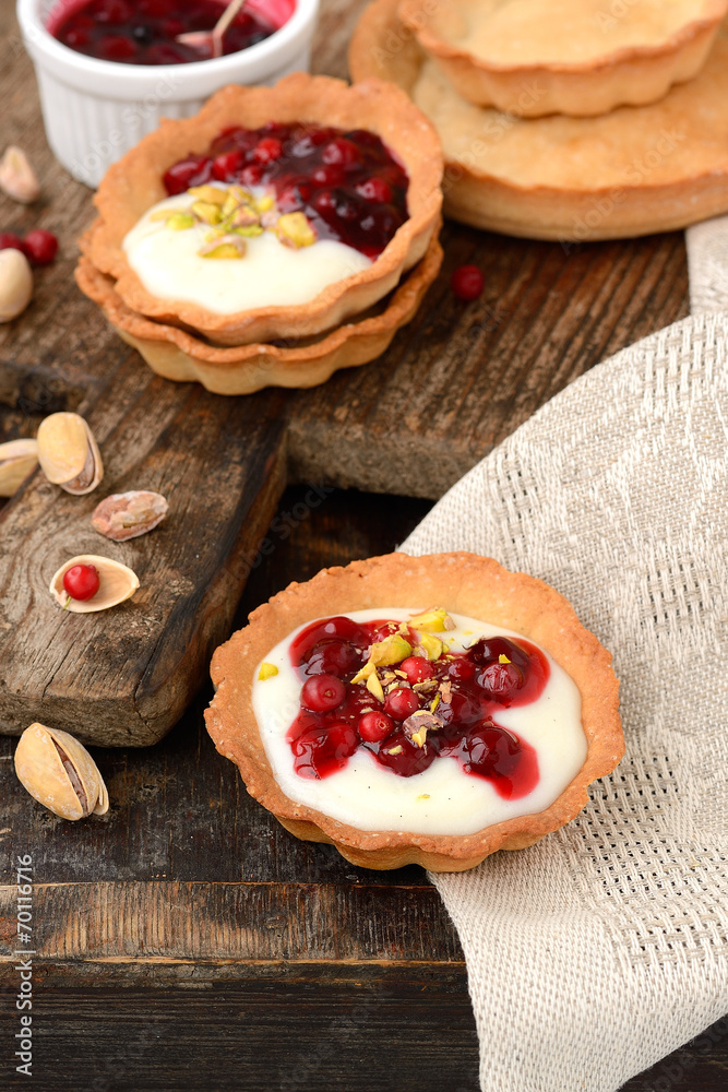 tartlets with cream, berry sauce and pistachios