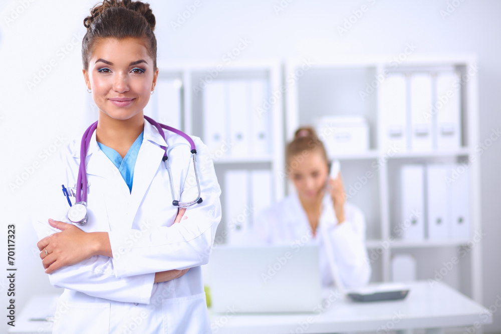 Portrait of young woman doctor with white coat standing in hosp Portrait of young woman doctor with white coat standing in hosp