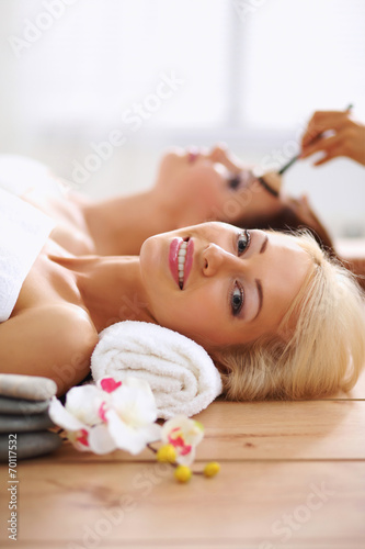 Two young beautiful women relaxing and enjoying at the spa cent