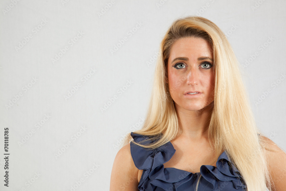 Naklejka premium Blond woman in blue dress looking thoughtful