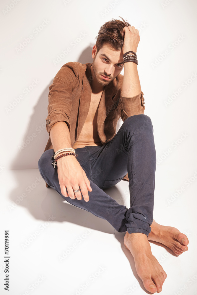 sad man sitting on the floor with his legs crossed sad man sitting on the floor with his legs crossed