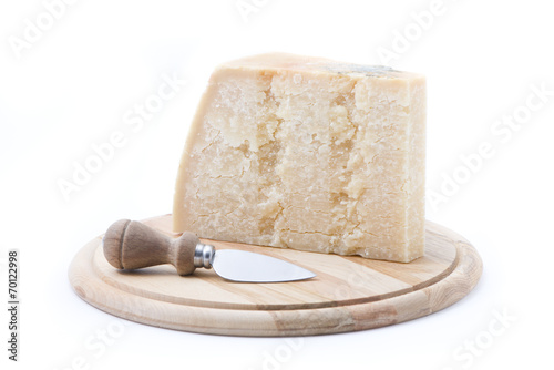formaggio grana su tagliere rotondo con coltello photo