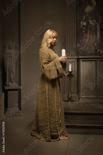 Nun praying in a medieval church