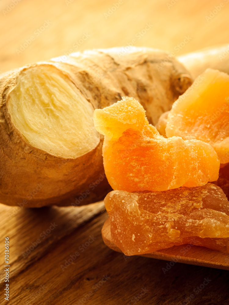 Closeup root and candied ginger on wooden table Closeup root and candied ginger on wooden table