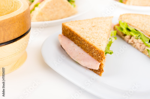 ham and lettuce sandwich on a white plate