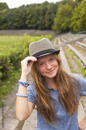 Young attractive girl in a straw hat in the park.
