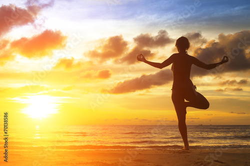 Yoga girl silhouette on the beautiful sea beach.