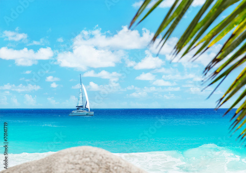 Beach with yacht and palm. Anse Georgette, Praslin, Seychelles
