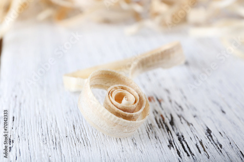 Wood shavings on white wooden background closeup