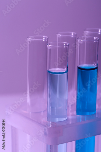 Test-tubes with blue liquid on purple background