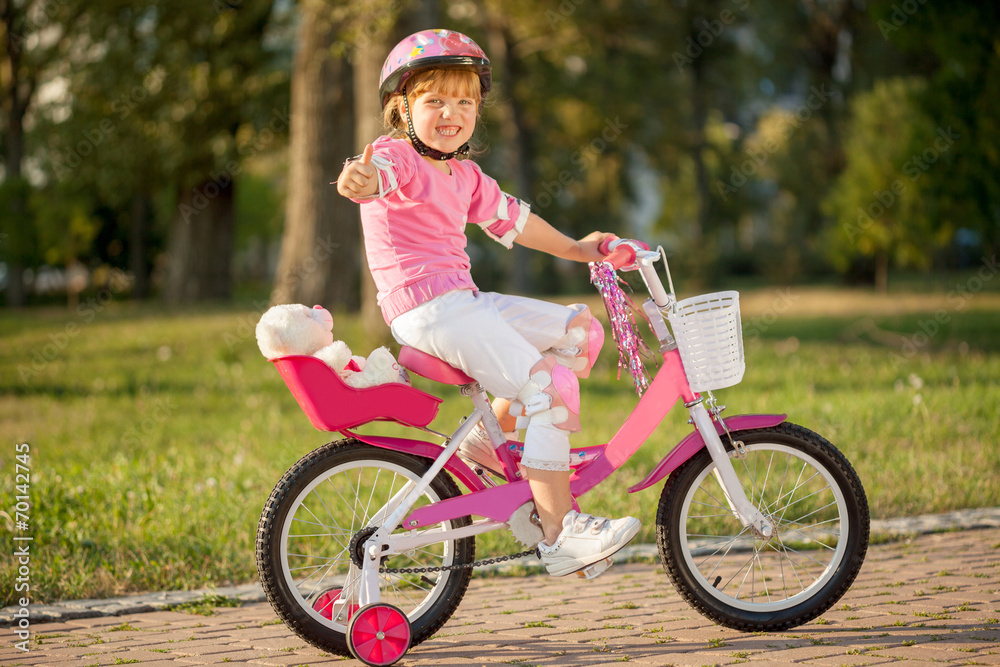 Portrait of a playful funny girl in a pink safety helmet on her Portrait of a playful funny girl in a pink safety helmet on her