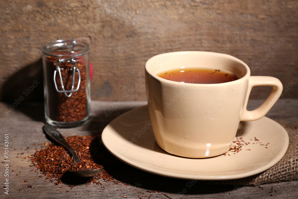 Cup of tasty rooibos tea, on wooden table Cup of tasty rooibos tea, on wooden table