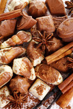 Different kinds of chocolates with spices close-up background