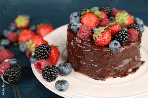 Tasty chocolate cake with different berries  on wooden table