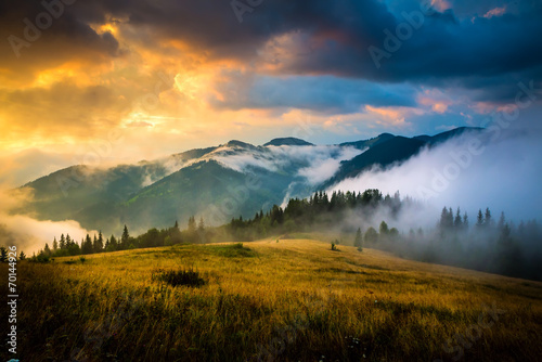 Fototapeta Naklejka Na Ścianę i Meble -  Amazing mountain landscape with fog and a haystack