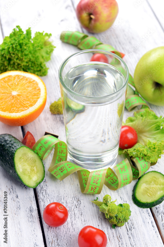 Glass of water with vegetables and measuring tape Glass of water with vegetables and measuring tape