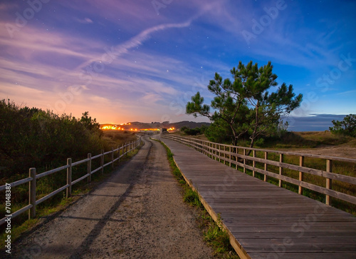 Wooden boardwalk and trail in the night photo