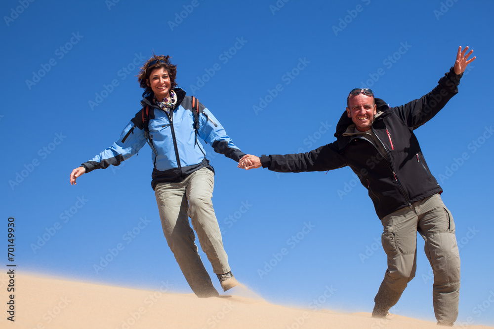 Coppia allegra corre sulla sabbia del deserto Coppia allegra corre sulla sabbia del deserto