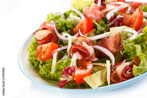 Vegetable salad with ham on white background