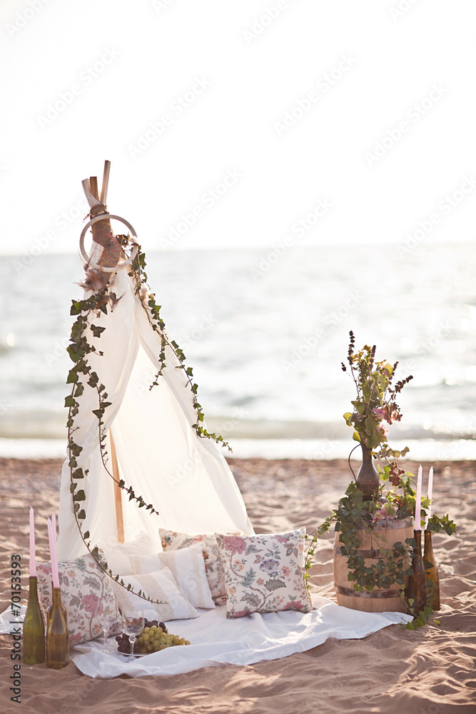 Tenderness couple on the beach picnic near wigwam