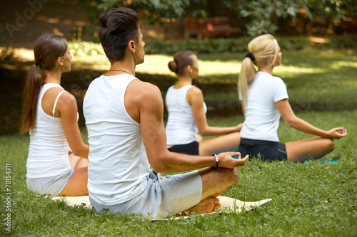 Yoga Class. Group of People Meditating At Summer Park