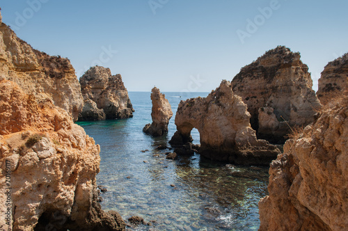 Algarve coast, Portugal. Rocks in the shoreline and blue water