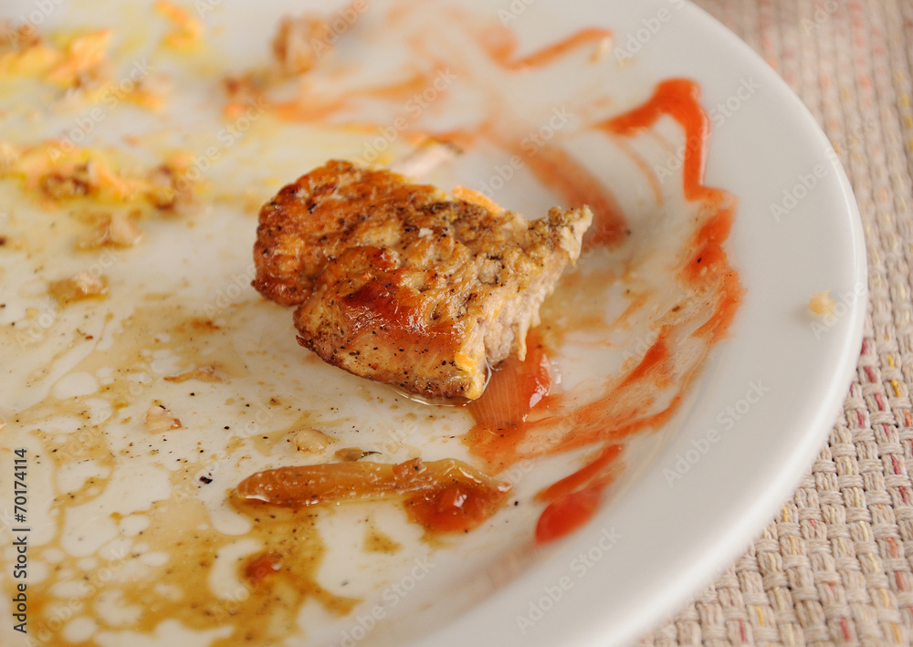 half-eaten piece of meat on the dirty plate half-eaten piece of meat on the dirty plate