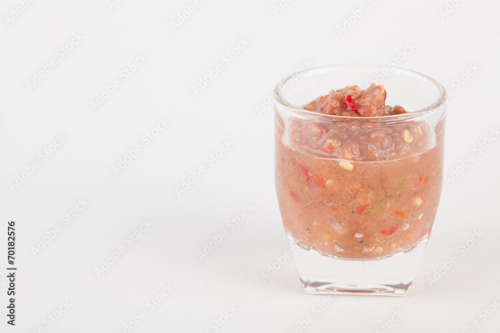 chili paste in glass on white paper background chili paste in glass on white paper background