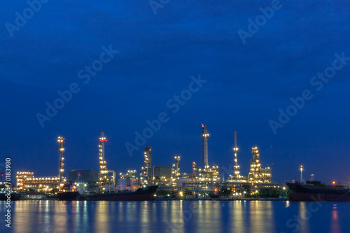 Oil refinery beside a river during twilight