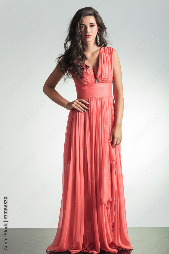 elegant woman in red dress standing with hand on hip