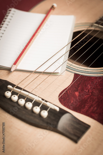 Notebook and pencil on guitar for writing music photo