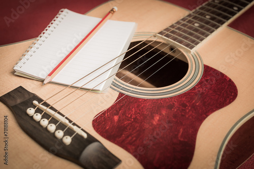 Notebook and pencil on guitar for writing music