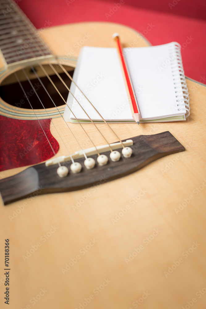 Fototapeta premium Notebook and pencil on guitar for writing music