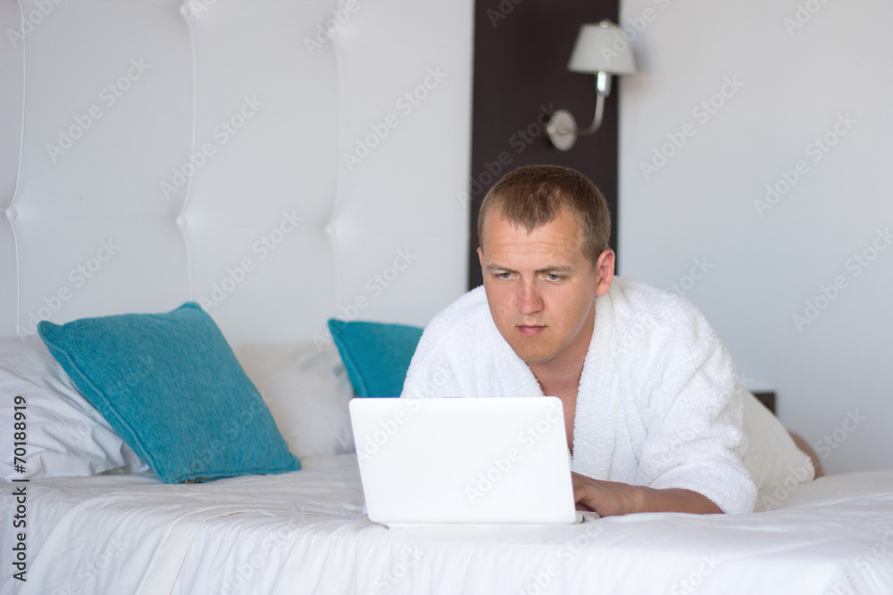 man in bathrobe with laptop in hotel room man in bathrobe with laptop in hotel room