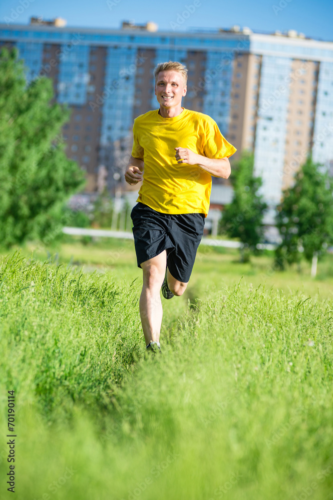 Sporty man jogging in city street park. Outdoor fitness. Sporty man jogging in city street park. Outdoor fitness.