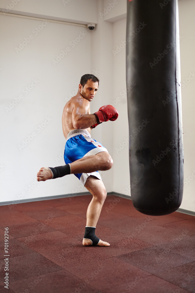 Kickboxer training with punchbag