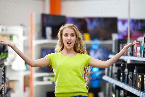 Красивая девушка в магазине телевизоров и электротехники