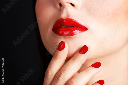 Woman s red lips and nails on dark background