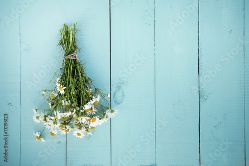 summer bouquet of chamomile on the old blue wooden background