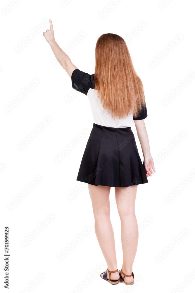 Back view of young redhead woman pointing at wall. beautiful gir Back view of young redhead woman pointing at wall. beautiful gir