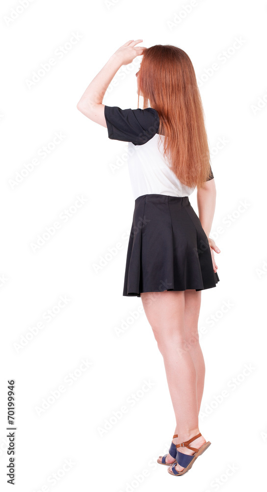 Back view of young redhead woman pointing at wall. Back view of young redhead woman pointing at wall.