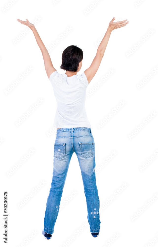 Back view of Beautiful woman in jeans looking at wall and Holds Back view of Beautiful woman in jeans looking at wall and Holds