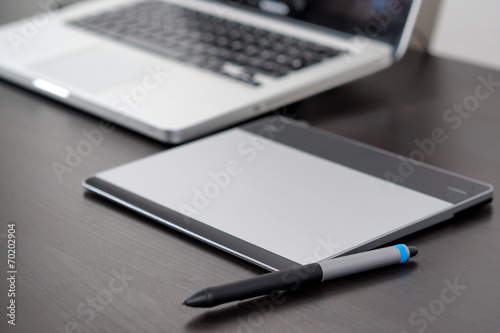 Graphic tablet on the table with notebook.