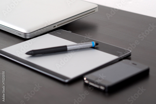 Graphic tablet on the table with notebook.