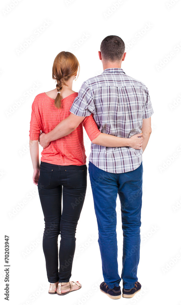 Back view of young embracing couple