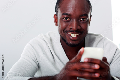 Portrait of a smiling african man with smartphone