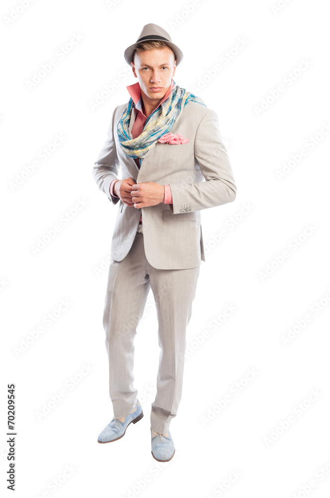 Fashionable male model wearing grey suit, scarf and hat.